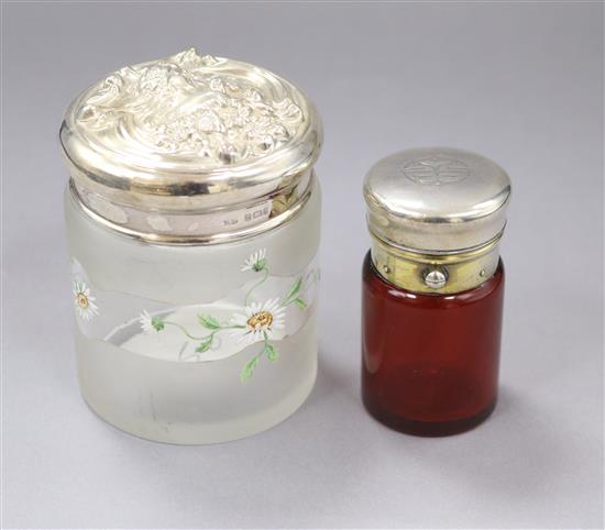 A late Victorian Art Nouveau repousse silver topped toilet jar, London, 1899 and a salts bottle.